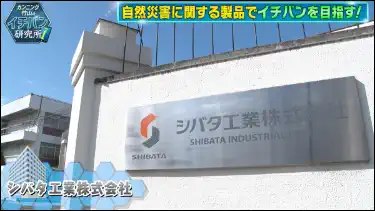 テレビ番組のキャプチャ画像。シバタ工業株式会社の正門が写っている。キャプション「自然災害に関する製品でイチバンを目指す！」